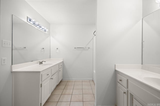 full bathroom with two vanities, tile patterned floors, baseboards, and shower / bath combination