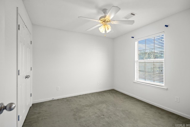 carpeted spare room with ceiling fan and baseboards