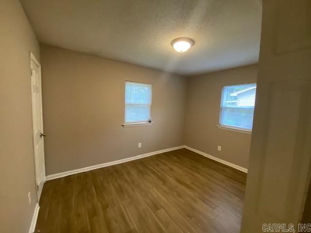 3804 Arapaho Trl, Little Rock, AR 72209 - empty room with healthy amount of natural light, baseboards, and dark wood-type flooring