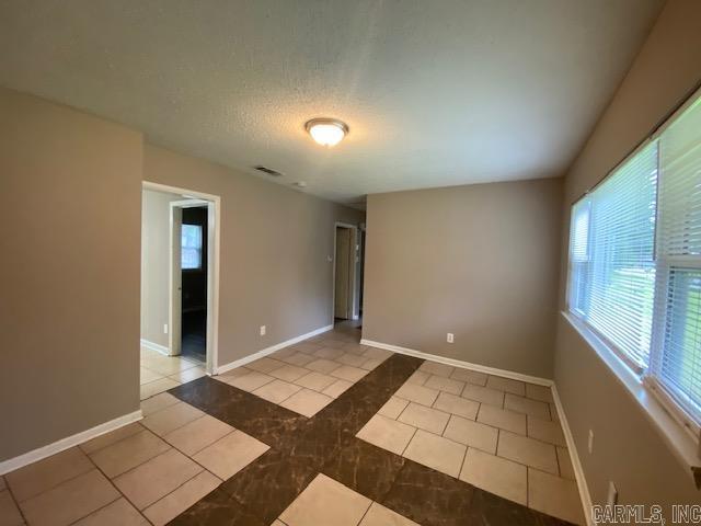 3804 Arapaho Trl, Little Rock, AR 72209 - unfurnished room featuring light tile patterned flooring, baseboards, and a textured ceiling