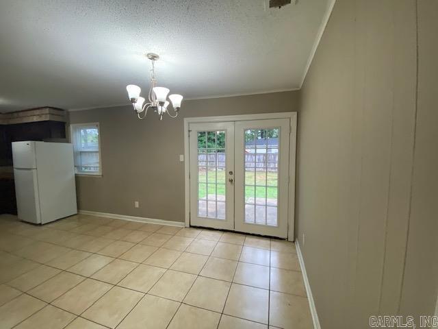 3804 Arapaho Trl, Little Rock, AR 72209 - unfurnished dining area with ornamental molding, light tile patterned floors, baseboards, french doors, and a chandelier