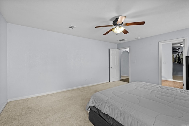 bedroom with baseboards, carpet flooring, a ceiling fan, and arched walkways