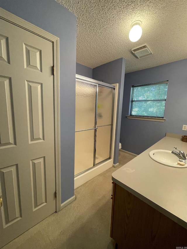 1502 Quail Creek Dr, Conway, AR 72032 - bathroom featuring a stall shower, a textured ceiling, vanity, toilet, and baseboards