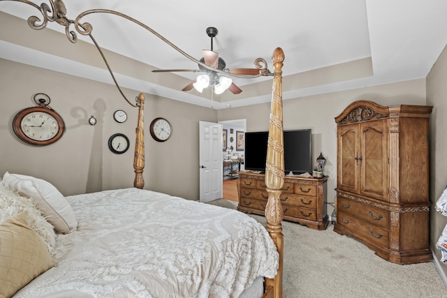 bedroom featuring a tray ceiling, carpet flooring, and ceiling fan