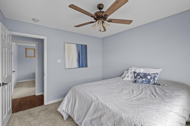 carpeted bedroom featuring baseboards and a ceiling fan