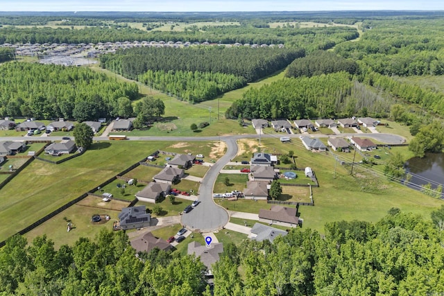 view of property location with a heavily wooded area and nearby suburban area