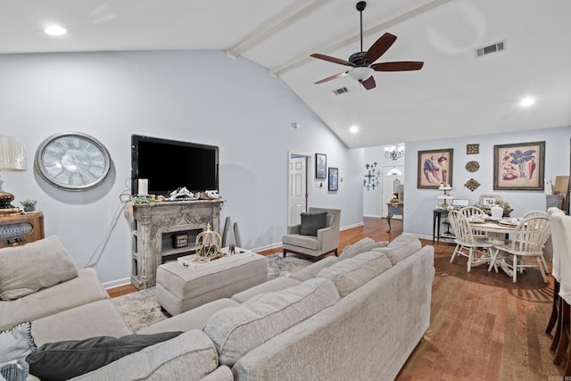 living area featuring ceiling fan, beam ceiling, wood finished floors, a fireplace with raised hearth, and high vaulted ceiling