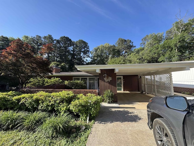 107 W Sunset, Sheridan, AR 72150 - view of front facade with driveway, an attached carport, and board and batten siding