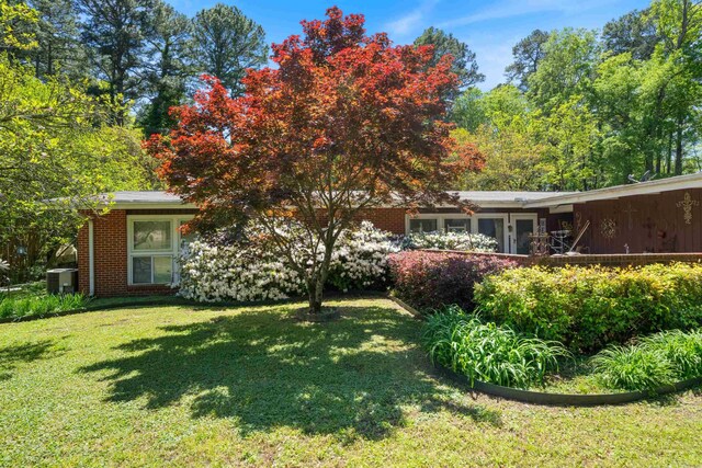 107 W Sunset, Sheridan, AR 72150 - back of property with a lawn, brick siding, and central AC