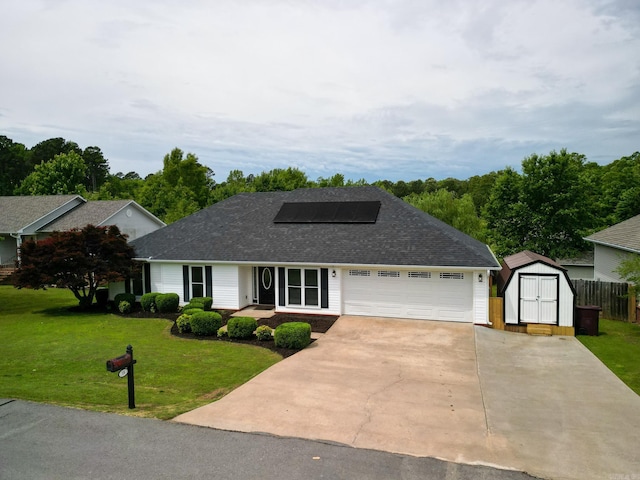 view of front of house featuring a shed, solar panels, concrete driveway, a garage, and roof with shingles