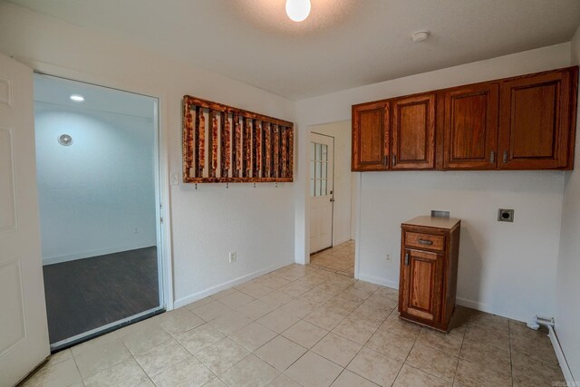 unfurnished room featuring light tile patterned floors, a smoke detector, and baseboards