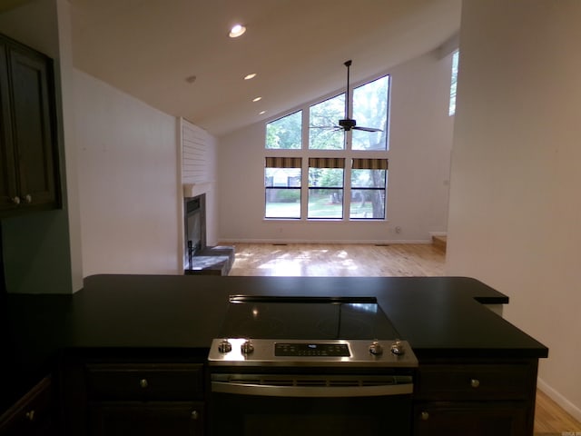 14301 Ridgewood, Little Rock, AR 72211 - kitchen with stainless steel electric range oven, dark countertops, a glass covered fireplace, light wood-type flooring, and ceiling fan