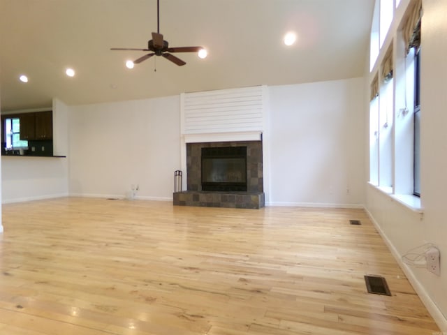 14301 Ridgewood, Little Rock, AR 72211 - unfurnished living room with light wood finished floors, a tiled fireplace, ceiling fan, healthy amount of natural light, and recessed lighting