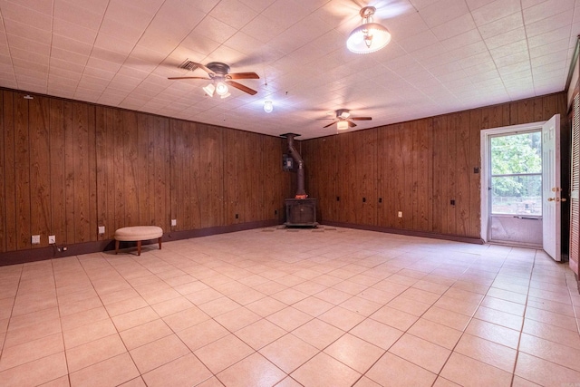 3815 Bruno Rd, Little Rock, AR 72209 - unfurnished room with ceiling fan, a wood stove, wood walls, and baseboards