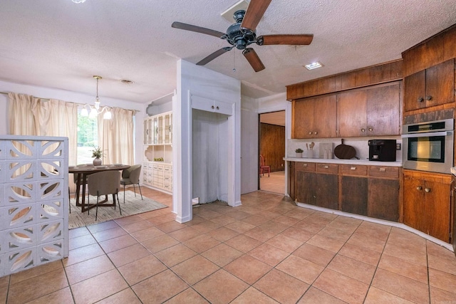 3815 Bruno Rd, Little Rock, AR 72209 - kitchen featuring oven, a chandelier, light tile patterned flooring, a textured ceiling, and a ceiling fan