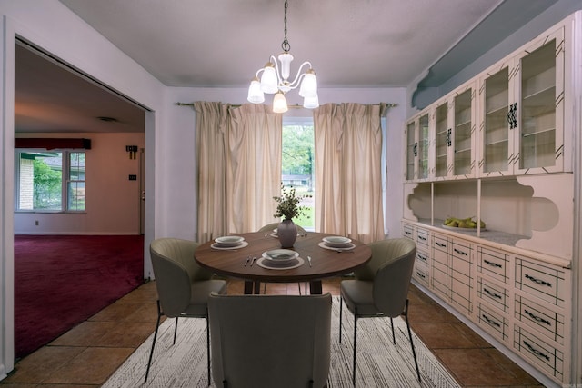3815 Bruno Rd, Little Rock, AR 72209 - dining area with a chandelier, dark colored carpet, dark tile patterned floors, and baseboards