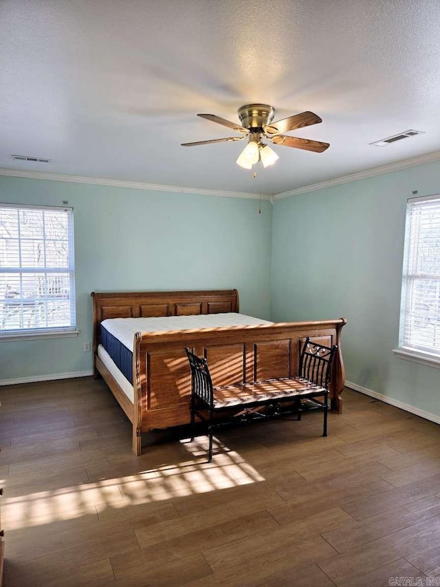 bedroom with ornamental molding, wood finished floors, baseboards, and a ceiling fan
