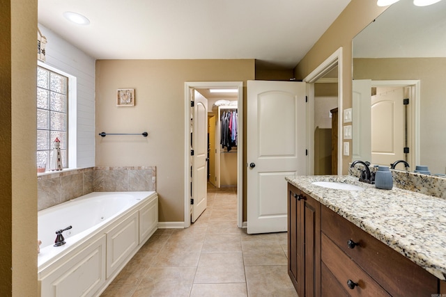 402 Demuth, Benton, AR 72019 - bathroom with vanity, a bath, a walk in closet, tile patterned flooring, and baseboards