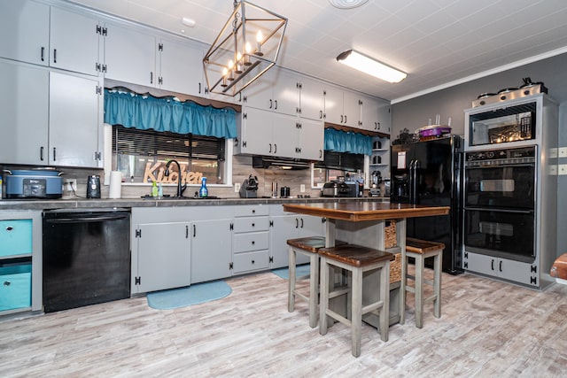 1705 W Cedar St, El Dorado, AR 71730 - kitchen featuring black appliances, dark countertops, a sink, light wood-type flooring, and crown molding