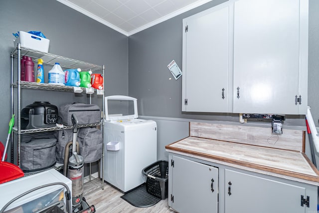 1705 W Cedar St, El Dorado, AR 71730 - laundry room featuring cabinet space, ornamental molding, light wood finished floors, and washer and clothes dryer