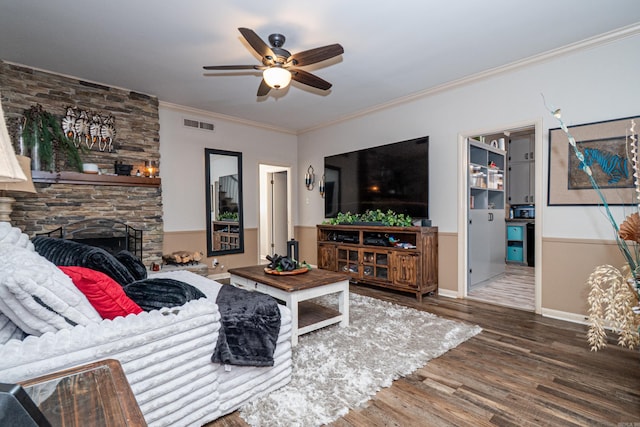 1705 W Cedar St, El Dorado, AR 71730 - living room with a ceiling fan, wood finished floors, a stone fireplace, and ornamental molding