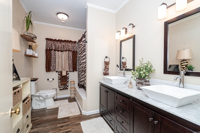 1705 W Cedar St, El Dorado, AR 71730 - full bathroom featuring wood finished floors, crown molding, toilet, double vanity, and baseboards