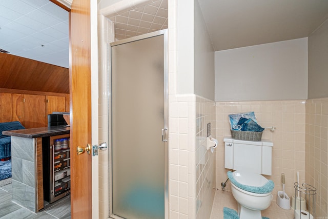 1705 W Cedar St, El Dorado, AR 71730 - bathroom with a stall shower, tile patterned floors, toilet, wainscoting, and tile walls