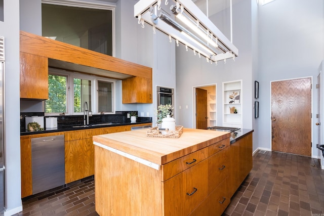 1 Rivers Edge Dr, Little Rock, AR 72227 - kitchen featuring a high ceiling, wood counters, brick patterned floors, a sink, and a kitchen island