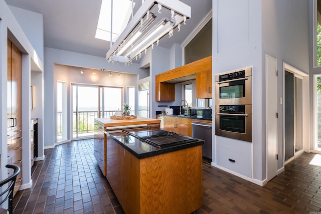 1 Rivers Edge Dr, Little Rock, AR 72227 - kitchen featuring track lighting, appliances with stainless steel finishes, a kitchen island, a sink, and dark countertops