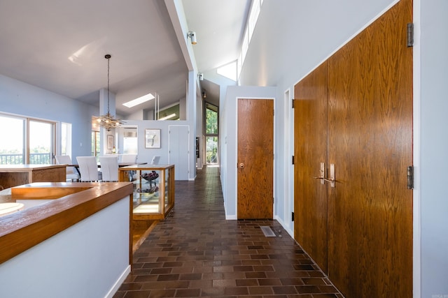 1 Rivers Edge Dr, Little Rock, AR 72227 - entrance foyer with brick floors, lofted ceiling, plenty of natural light, a chandelier, and baseboards