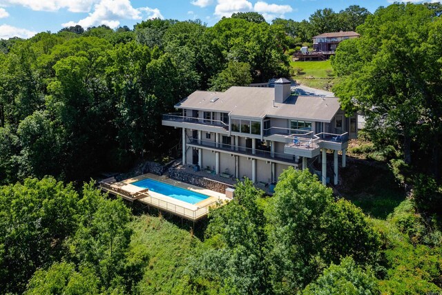 1 Rivers Edge Dr, Little Rock, AR 72227 - rear view of house featuring an outdoor pool, a chimney, and a forest view