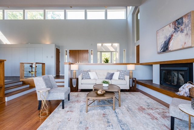1 Rivers Edge Dr, Little Rock, AR 72227 - living area with a towering ceiling, a glass covered fireplace, wood finished floors, and healthy amount of natural light