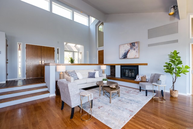 1 Rivers Edge Dr, Little Rock, AR 72227 - living area with wood finished floors, a towering ceiling, baseboards, and a glass covered fireplace