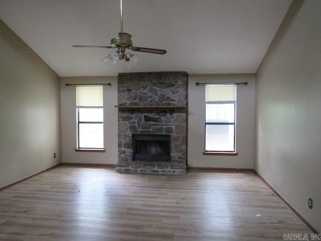 unfurnished living room featuring plenty of natural light, lofted ceiling, wood finished floors, and a ceiling fan