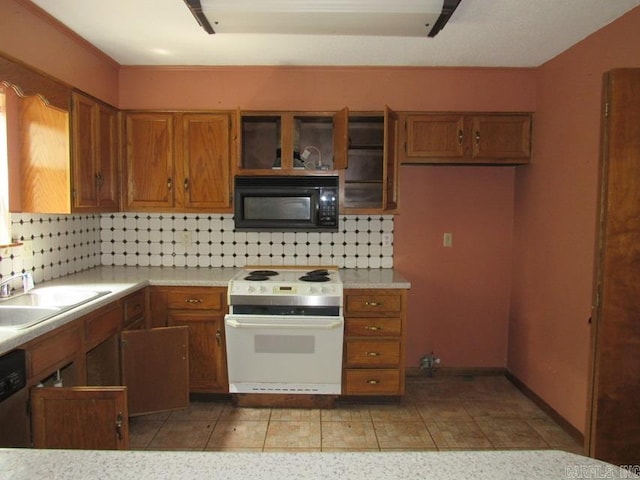 kitchen with white electric range oven, black microwave, a sink, and brown cabinets