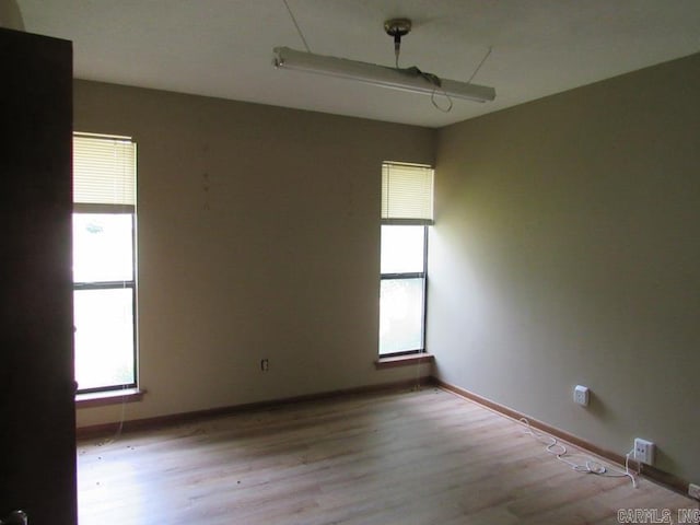 spare room with light wood finished floors and baseboards