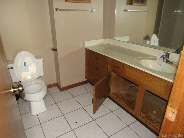 bathroom featuring toilet, vanity, tile patterned flooring, and baseboards