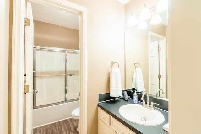204 Riverside Dr, Pangburn, AR 72121 - full bathroom with toilet, vanity, wood finished floors, and bath / shower combo with glass door
