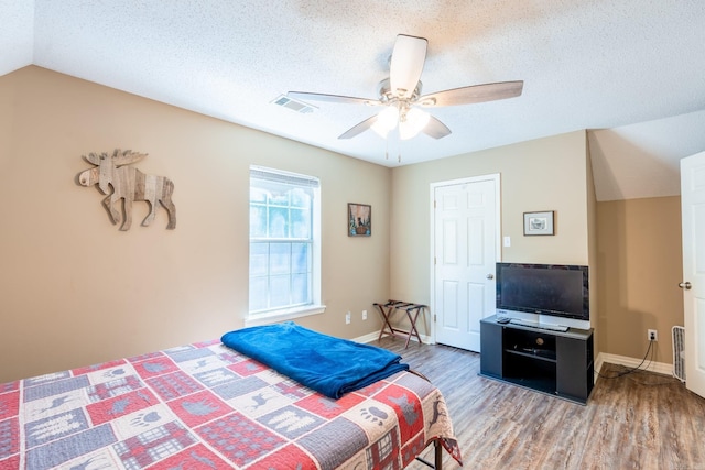204 Riverside Dr, Pangburn, AR 72121 - bedroom featuring wood finished floors, a textured ceiling, baseboards, ceiling fan, and lofted ceiling