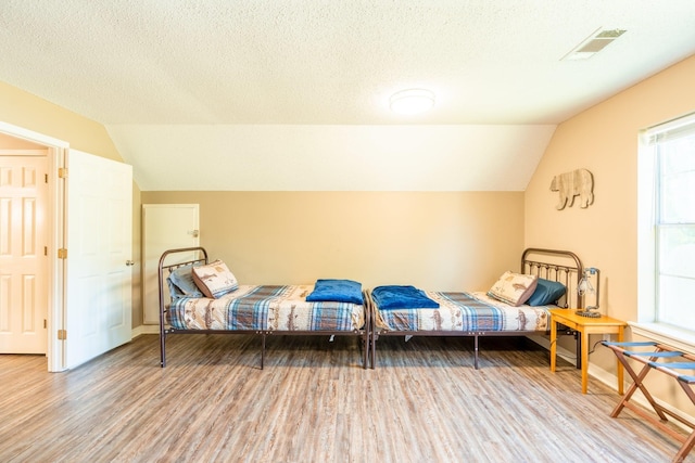 204 Riverside Dr, Pangburn, AR 72121 - bedroom with lofted ceiling, wood finished floors, baseboards, and a textured ceiling