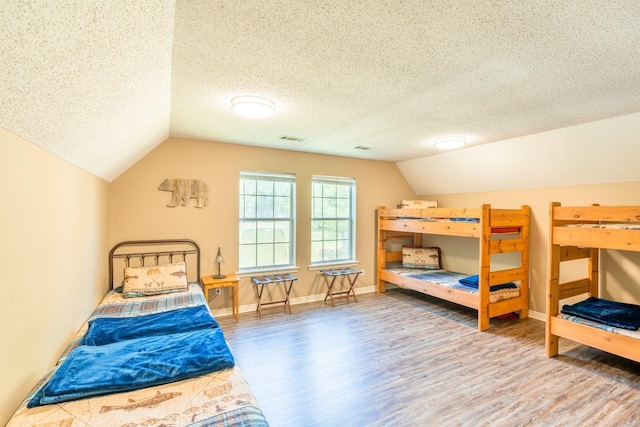 204 Riverside Dr, Pangburn, AR 72121 - bedroom with wood finished floors, lofted ceiling, a textured ceiling, and baseboards