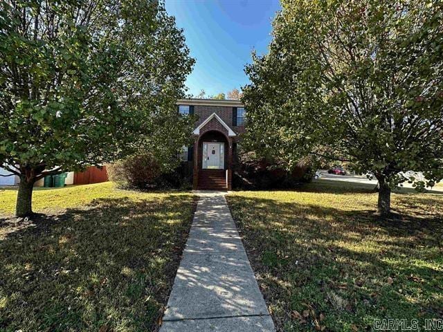 obstructed view of property with a front lawn