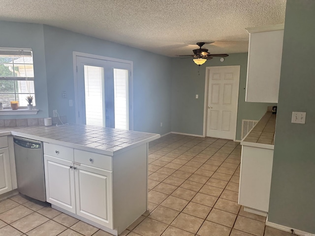 kitchen featuring dishwasher, tile countertops, a peninsula, ceiling fan, and a textured ceiling