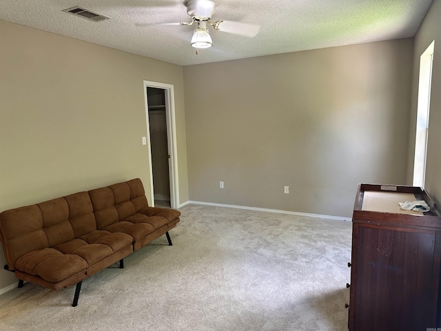 sitting room featuring carpet, a ceiling fan, a textured ceiling, and baseboards