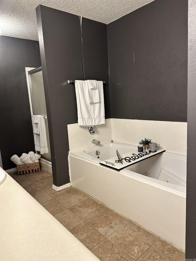 full bathroom with a textured ceiling, a shower stall, a jetted tub, and tile patterned floors