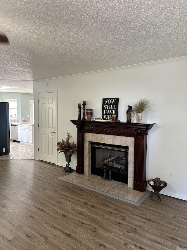 living area featuring a textured ceiling, wood finished floors, a fireplace, and baseboards