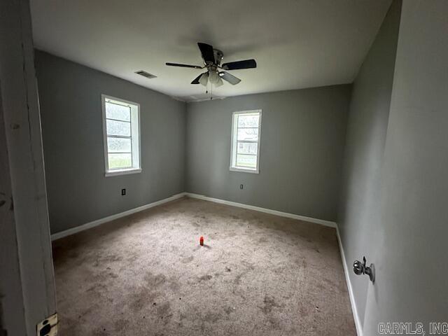 unfurnished room with ceiling fan, baseboards, and carpet