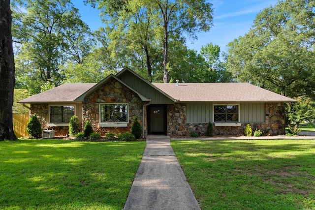 view of front of house with stone siding, roof with shingles, and board and batten siding
