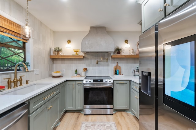kitchen featuring appliances with stainless steel finishes, a sink, open shelves, and gray cabinets