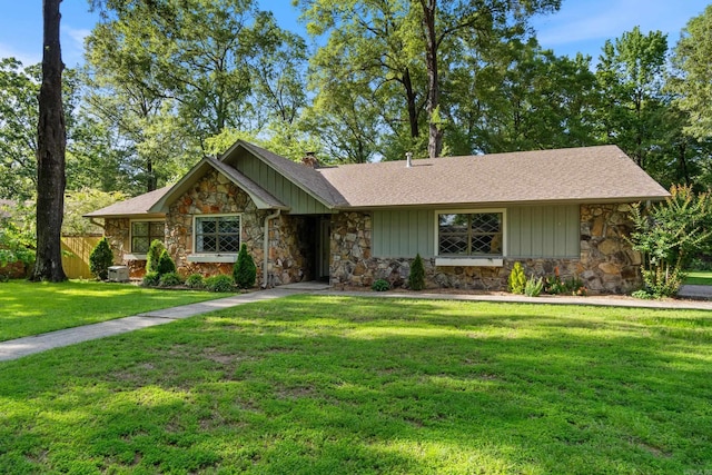 view of front of house with stone siding, a chimney, and a shingled roof
